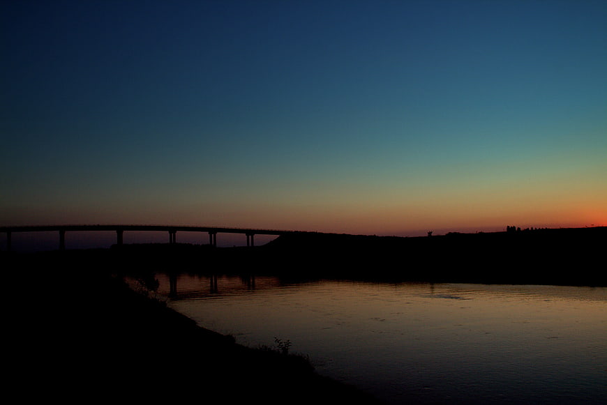 Silhouette of Bridge Over River at Sunset