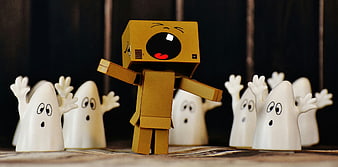 Cardboard box character crying surrounded by small white ghosts