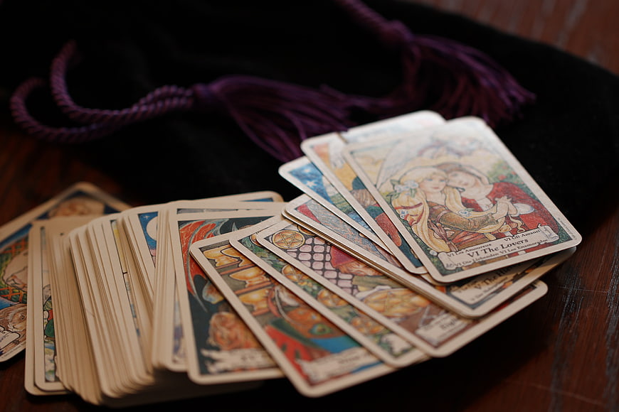 Spread of Tarot Cards on Wooden Table with Purple Tassel
