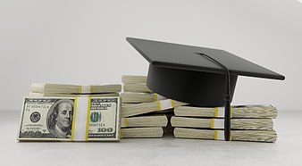 Graduation Cap Resting On Stacks Of US Dollar Bills