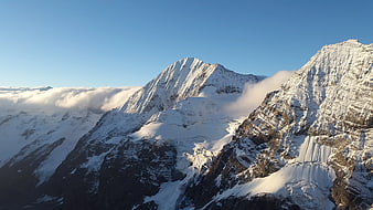 Majestic Snow-Capped Mountain Peaks Above Clouds