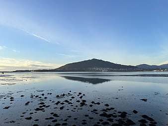 Serene coastal landscape with mountain reflection at low tide