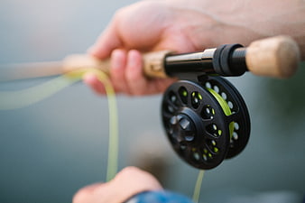 Close-up of fly fishing reel and rod in hand