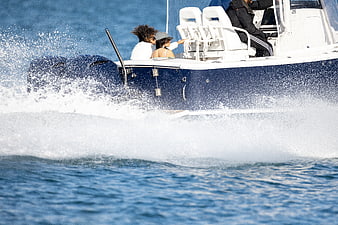 Couple on speeding motorboat creating ocean spray