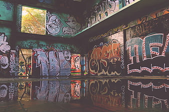 Colorful graffiti art in abandoned urban interior with reflections