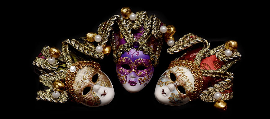 Three ornate Venetian carnival masks with gold and pearl details on black background