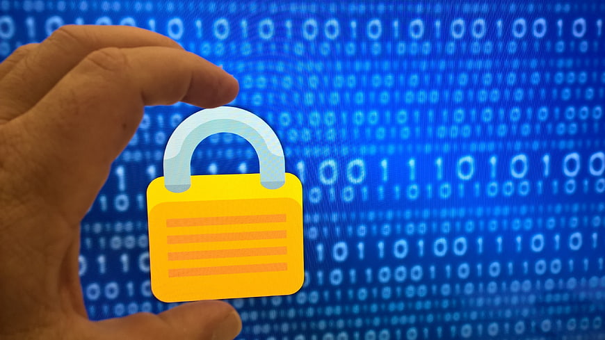 Hand holding padlock icon over binary code background