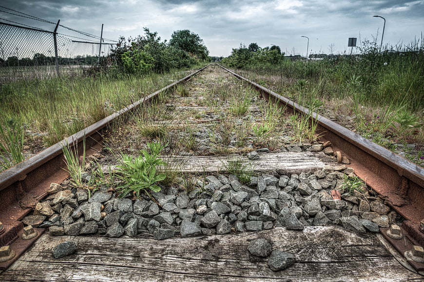 Overgrown abandoned railway tracks leading into the distance