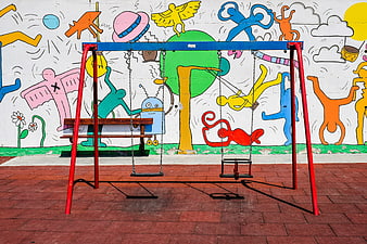 Colorful Swing Set in Front of Vibrant Street Art Mural