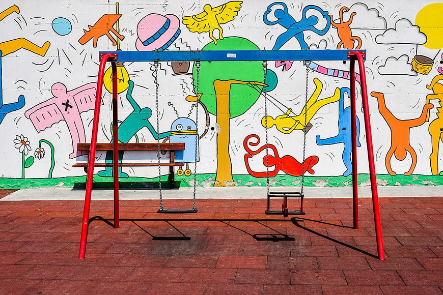 Colorful Swing Set in Front of Vibrant Street Art Mural