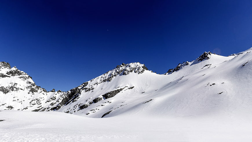 Snowy Mountain Peaks Under Clear Blue Sky