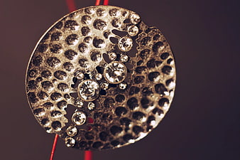 Close-up of textured silver jewelry pendant with rhinestones