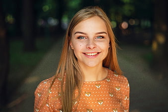 Portrait of smiling young blonde woman in park