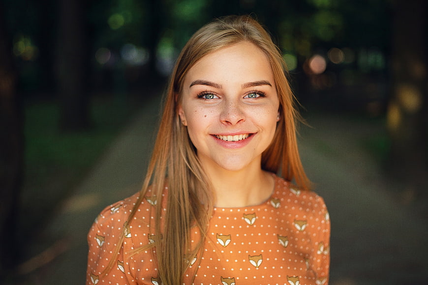 Portrait of smiling young blonde woman in park