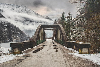 Snowy Concrete Arch Bridge in Winter Mountain Landscape