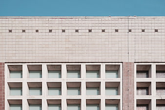 Modernist Building Facade with Grid Windows and Blue Sky