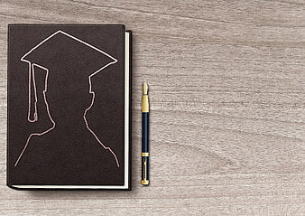 Graduation Cap Embossed Notebook and Fountain Pen on Wooden Table