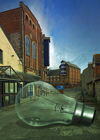 Giant light bulb in urban street with brick buildings