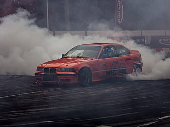 Red BMW E36 Drifting Car Generating Thick Tire Smoke On Wet Asphalt Track