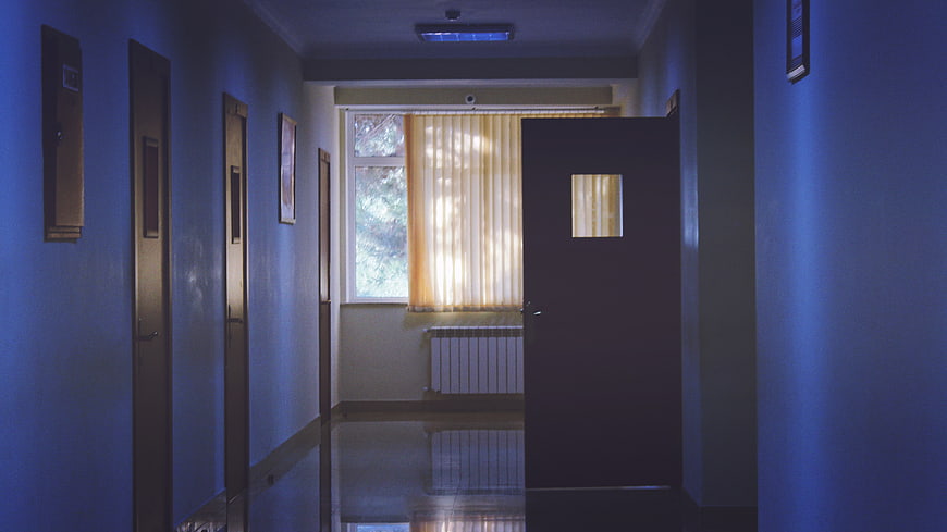 Empty Blue Hospital Corridor with Open Door