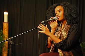 African American Woman Singing into Microphone on Stage