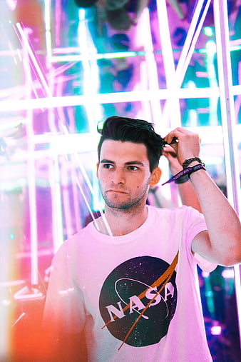 Young man in NASA t-shirt against neon lights