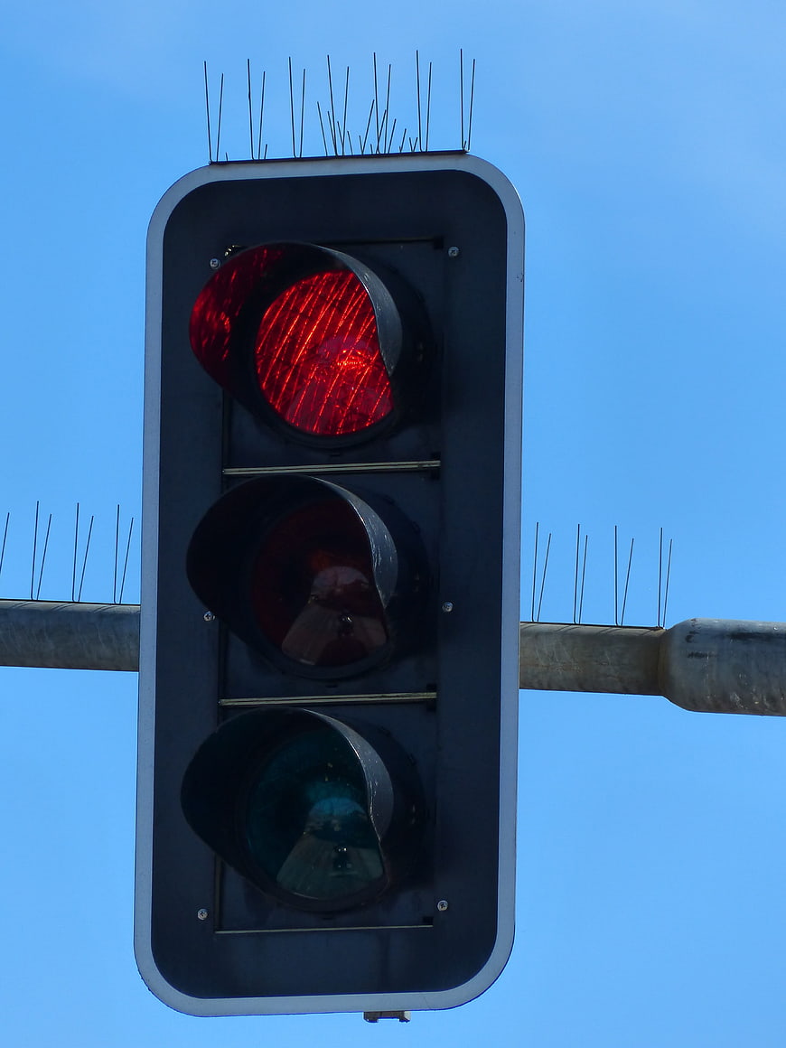 Red Traffic Light Signal Against Blue Sky