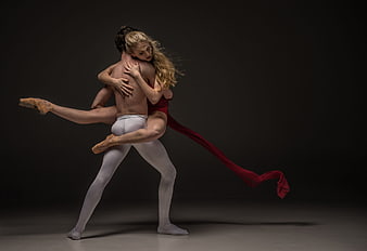 Ballet Dancers in Dramatic Lift Pose with Red Fabric