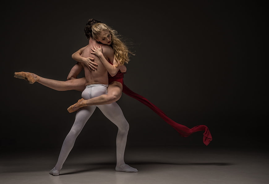 Ballet Dancers in Dramatic Lift Pose with Red Fabric