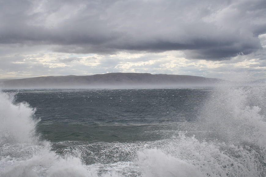 Dramatic Sea Waves Crashing Against Rocky Coast Under Stormy Sky