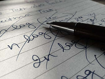 Close-up of handwritten math notes with pen on paper