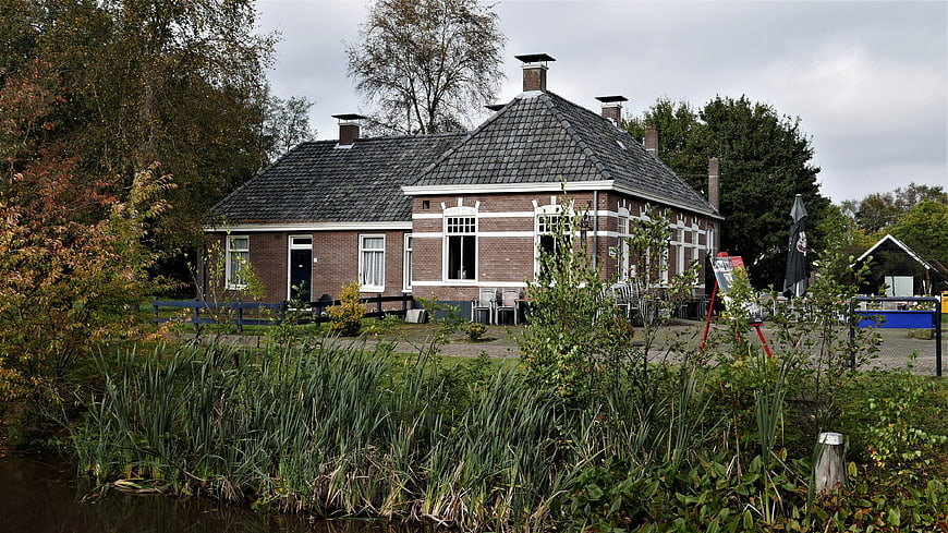 Traditional Dutch brick farmhouse by a canal in autumn