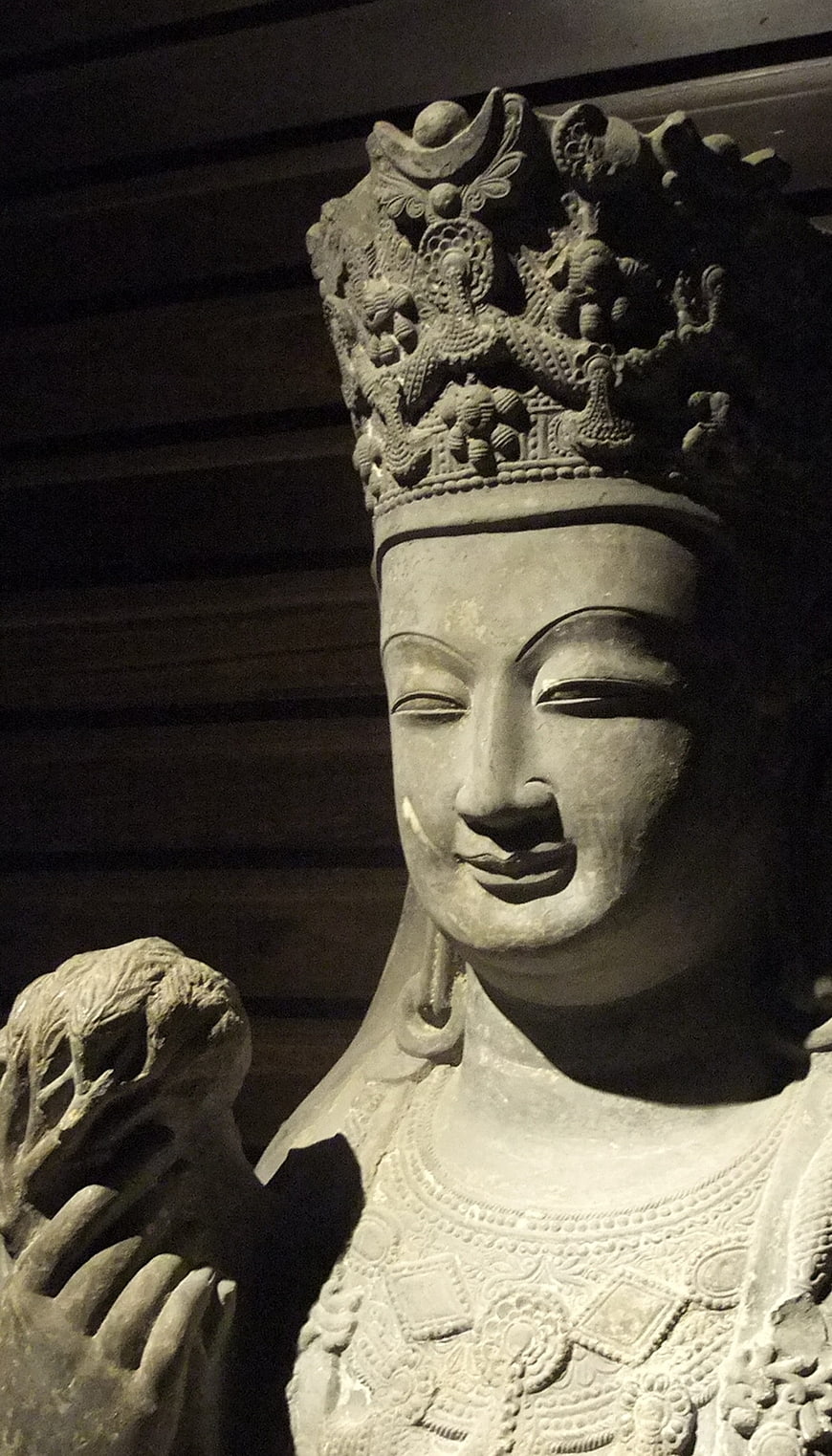 Close-up of ancient stone Buddha statue with intricate crown