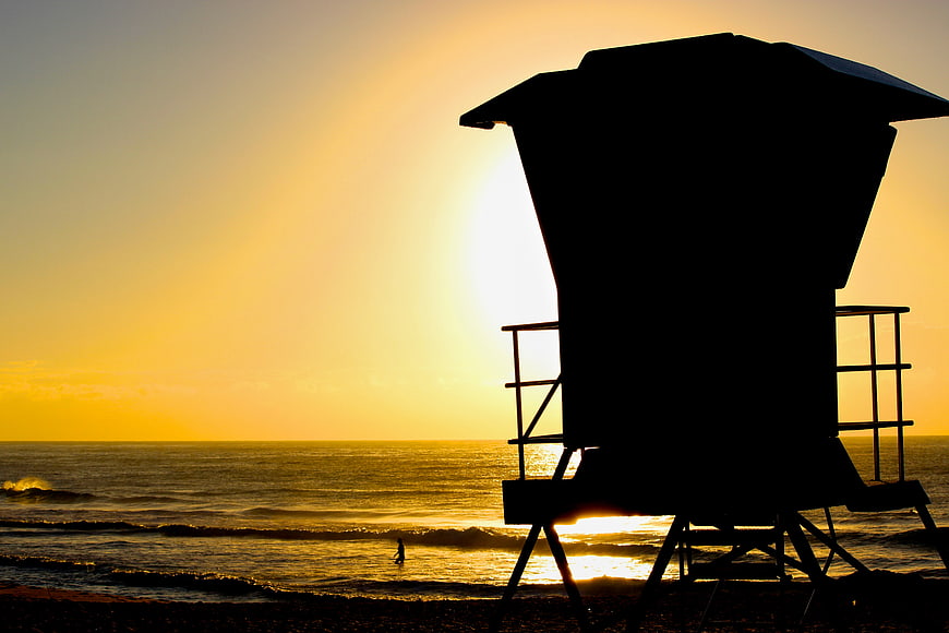 Silhouette of Lifeguard Tower at Sunset on Ocean Beach