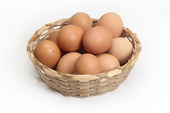 Fresh Brown Eggs in Woven Basket on White Background