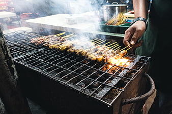 Grilling Chicken Satay Skewers on Charcoal Grill