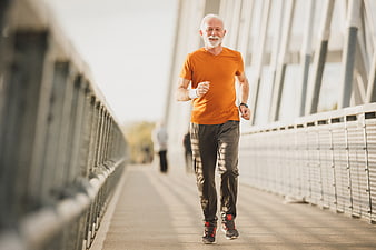 Senior man jogging on bridge