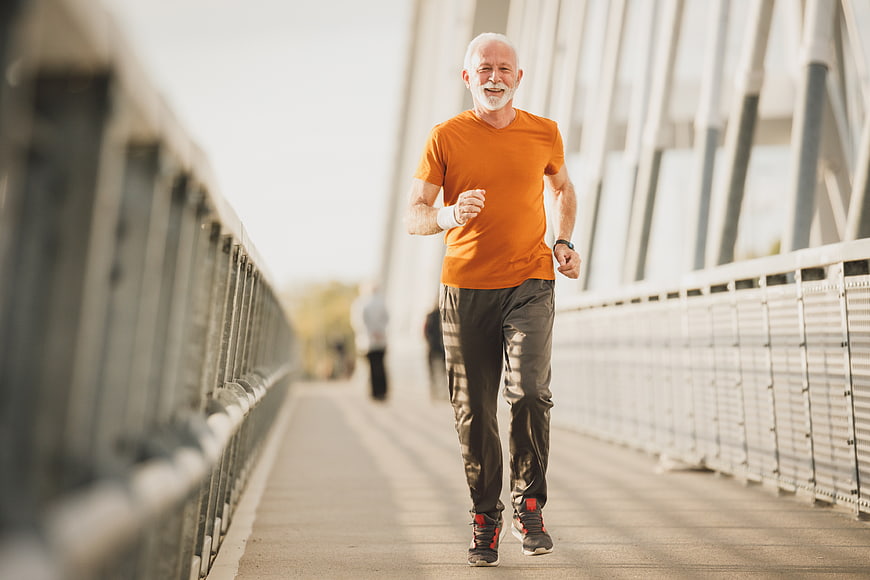 Senior man jogging on bridge