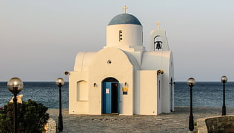 White Greek Orthodox Church with Blue Dome by the Sea
