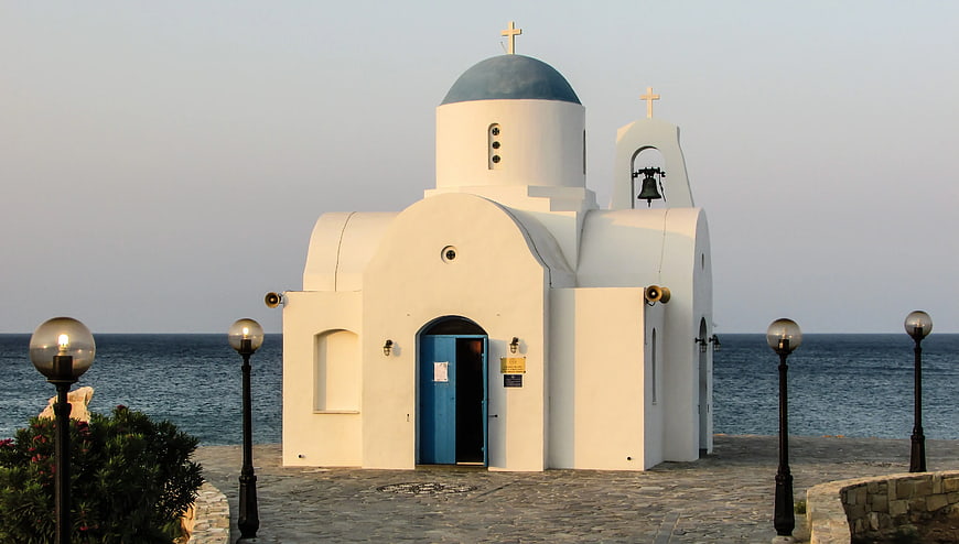 White Greek Orthodox Church with Blue Dome by the Sea