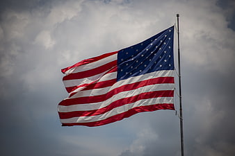 American Flag Waving Against Dramatic Cloudy Sky