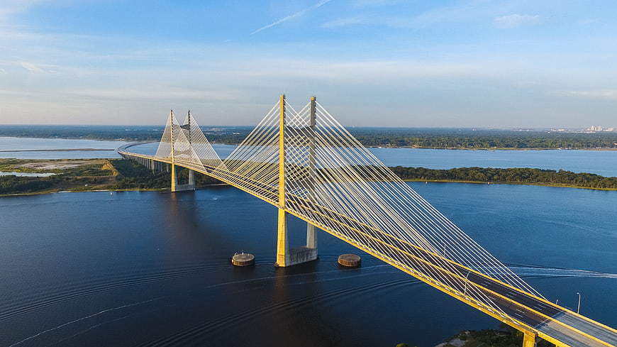 Aerial View of Yellow Cable-Stayed Bridge Over Blue Water