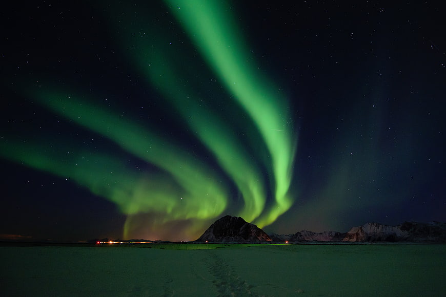 Vibrant Green Aurora Borealis Over Snowy Mountain Landscape