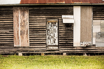 Weathered wooden shed with corrugated iron panels and peeling paint