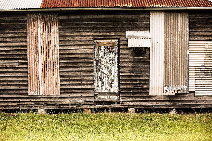 Weathered wooden shed with corrugated iron panels and peeling paint