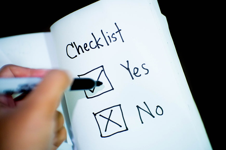 Hand Checking Yes Box on Paper Checklist