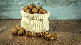 Walnuts in a Knitted Bag on a Wooden Table