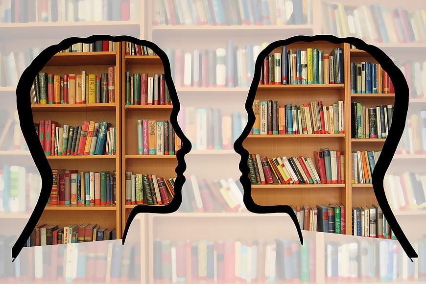 Two Silhouetted Heads Filled With Books Representing Knowledge And Communication