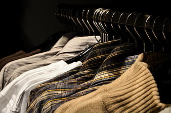 Clothing on Hangers in Dark Wardrobe