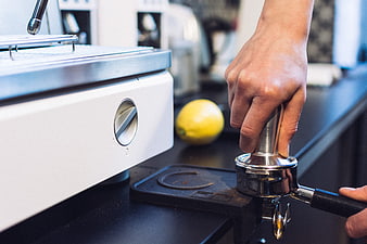 Barista tamping espresso grounds in portafilter